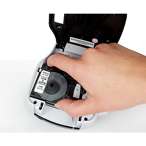 Een hand die een labelcartridge in een labelapparaat plaatst. Op de cartridge staat ZWART WIT.