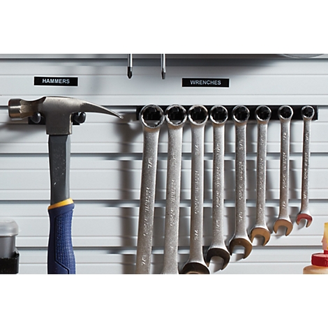 Un marteau et des clés sont suspendus à un mur d'outils. Les étiquettes MARTEAUX et CLÉS sont au-dessus des outils.