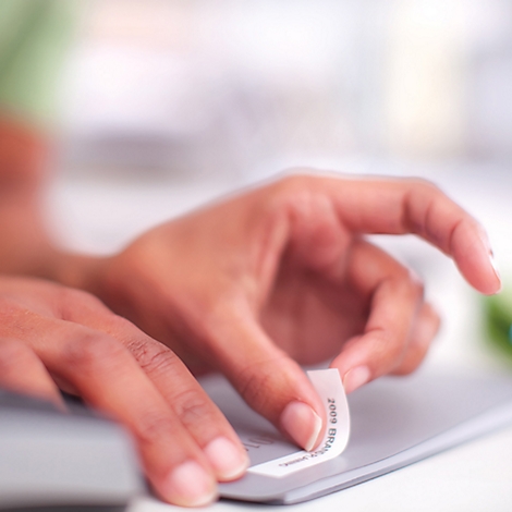 Eine weiße Schachtel mit DYMO Standard Label Etiketten. Aufschrift: DYMO, 20x, 12 mm x 7 m. Mit grünem Etikett: BUY MORE, SAVE MORE.