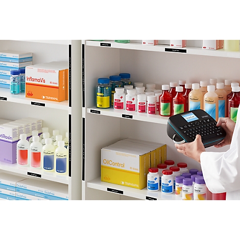 Schap met medicijnen. Persoon labelt flessen met een labelmachine.