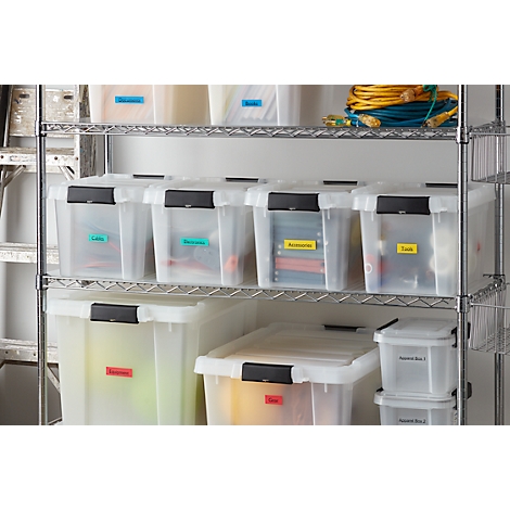 Étagère avec des boîtes de rangement transparentes étiquetées avec des étiquettes colorées pour les câbles, les outils et les accessoires. Des câbles jaunes et bleus sont en haut.