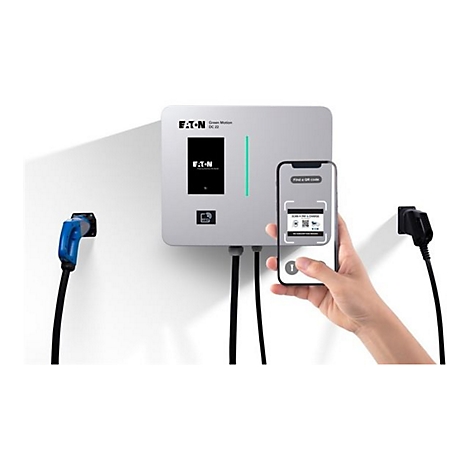 Eine Person scannt mit einem Smartphone einen QR-Code auf einer Ladestation für Elektrofahrzeuge. Im Bild sind eine Ladestation, eine blaue und eine schwarze Ladesäule zu sehen.