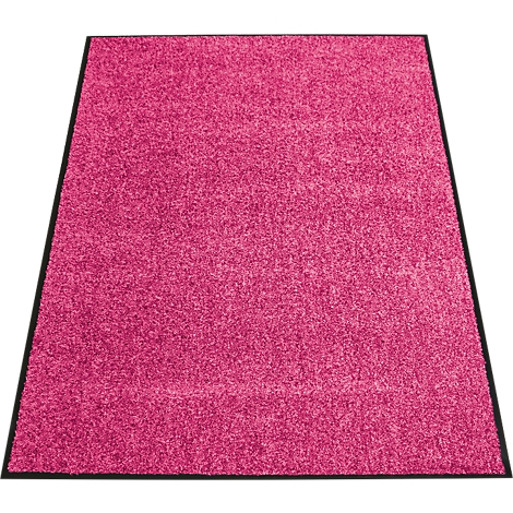 Een roze tapijt met een zwarte rand. Het tapijt heeft een ruw oppervlak en ligt op een witte ondergrond.