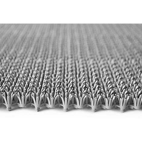 Primer plano de una alfombrilla de plástico gris texturizada con elementos tipo cepillo.