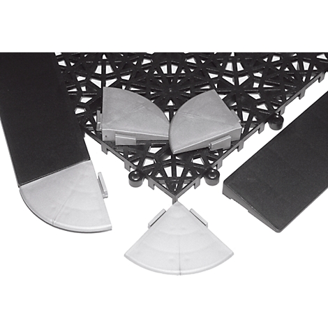 Verschiedene Elemente eines Bodenbelagsystems: Eckstücke, Rampen und schwarze Fliesen mit sechseckigem Muster.