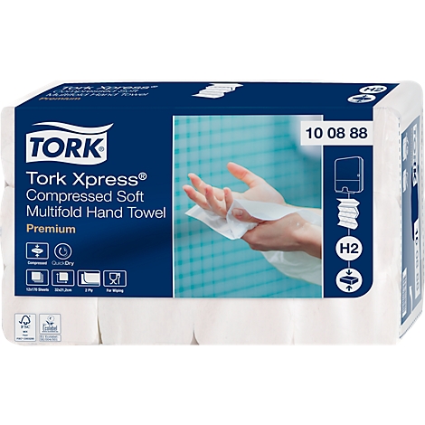 Witte Tork Xpress handdoeken, een persoon neemt er een uit de dispenser. De achtergrond is wazig, met een blauw patroon.