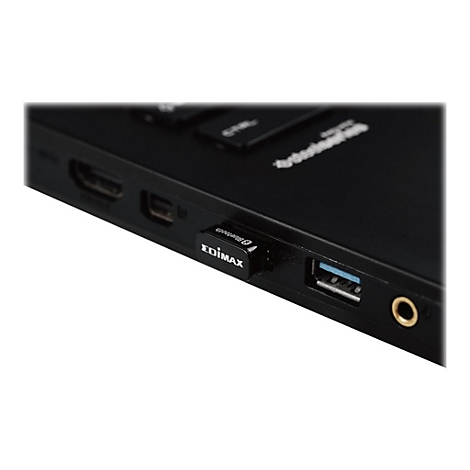 Ein kleiner Edimax Bluetooth-Adapter steckt in einem USB-Anschluss an der Seite eines schwarzen Laptops.