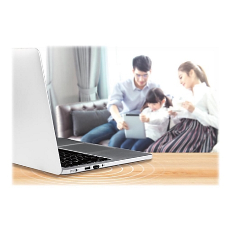 Ein Laptop im Vordergrund. Im Hintergrund sitzt eine Familie auf dem Sofa und benutzt ein Tablet.
