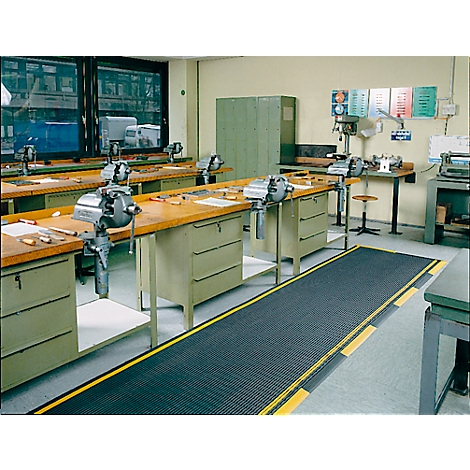 Workshop with workbenches, vices, and machines. Black flooring with yellow stripes.