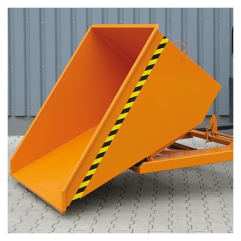 Orangener Kippbehälter vor grauer Wand. Schwarze und gelbe Warnstreifen an der Seite.