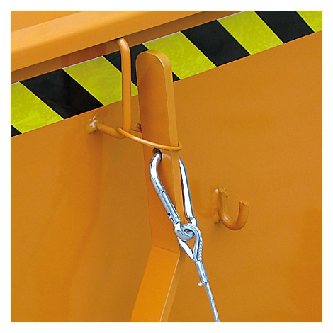 Detailaufnahme einer orangefarbenen Metallkonstruktion mit gelb-schwarzem Warnstreifen. Ein Stahlseil ist mit Karabinerhaken befestigt.