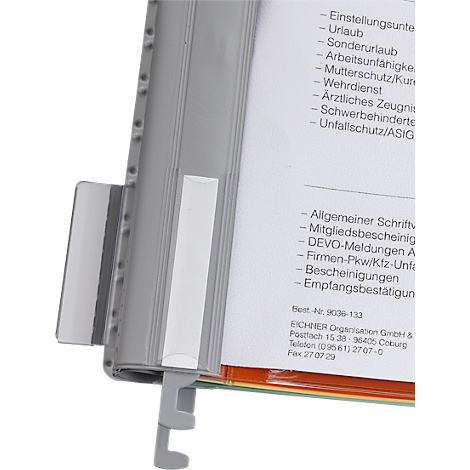 Grey wall mount with documents. Text visible on the document includes 'Holiday' and 'Membership certificates'.