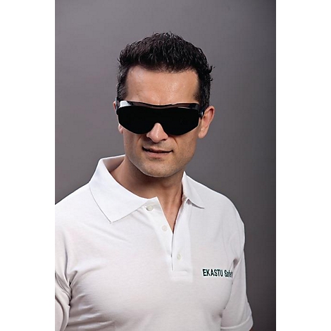 Un homme aux cheveux noirs porte des lunettes de sécurité et un polo blanc. Le polo porte l'inscription 'EKASTU Safety'.