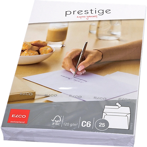 A person writing with a pen on paper. Pastries, a drink, and envelopes are on a table.