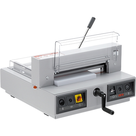 Gray paper cutter with operating lever and protective device. The device is on a table.