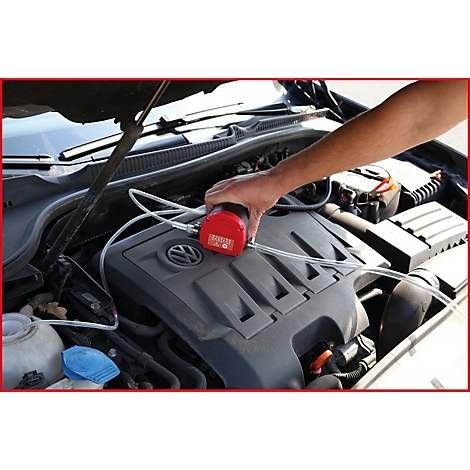 Hand hält rotes Gerät über Motor. Schläuche sind angeschlossen. Volkswagen-Logo.