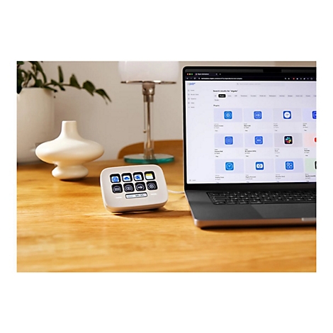 Ein weißes Stream Deck neben einem Laptop. Auf dem Laptop-Bildschirm sind Plugins für Elgato zu sehen.