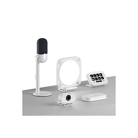 Studio-Setup mit Mikrofon, Webcam, Ringlicht, Bedienfeld und kabelloser Ladevorrichtung, alle weiß. Auf grauer Oberfläche.
