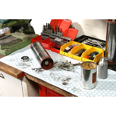 Cilindro y herramientas en un banco de trabajo. Se ve un rodamiento, una lata, taladros y una aceitera.