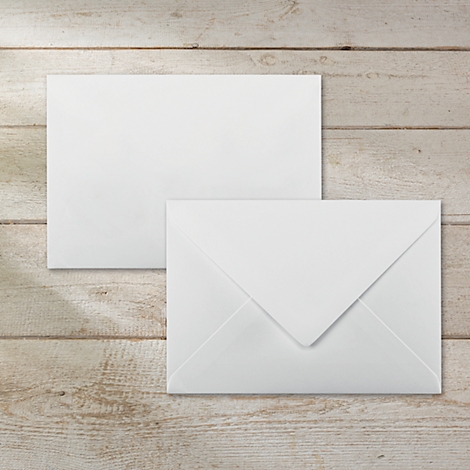 Two white envelopes on a light wooden surface. One is open, the other is closed.