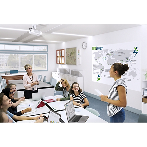 Students listen to a classmate giving a presentation on renewable energy. A projector is in the background.
