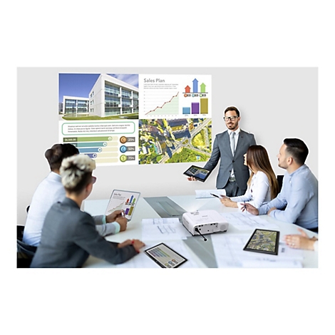 Ein Team diskutiert einen Projektor in einem Meetingraum, während Diagramme an die Wand projiziert werden.