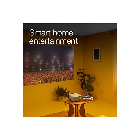 Ein gelbes Zimmer mit Projektor, der ein Konzert zeigt, auf einem Tisch. Schriftzug: Smart Home Entertainment.