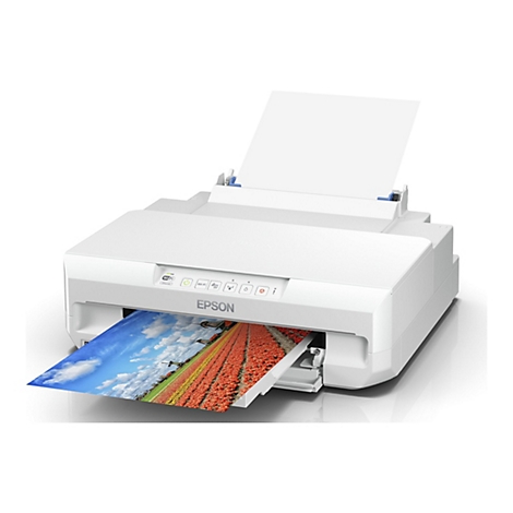 Une imprimante blanche imprime une photo en couleur. Une feuille de papier est posée dessus. L'image imprimée montre des moulins à vent et un champ de fleurs.