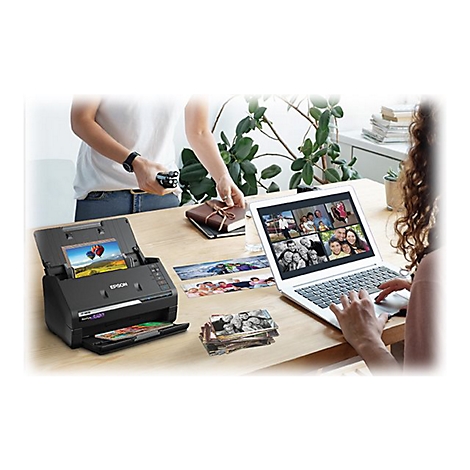 Une personne numÃ©rise des photos avec un scanner Epson, tandis qu'une autre imprime des photos et travaille sur un ordinateur portable.