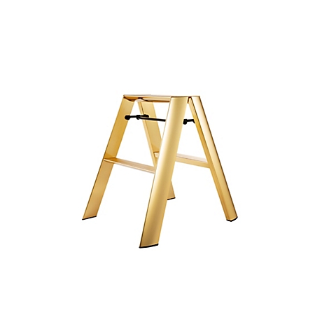 Tabouret doré, autoportant, sur fond blanc. Barre transversale noire, design élégant.