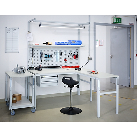 Workbench with tools. On the wall a pegboard with tools, a whiteboard on the left.