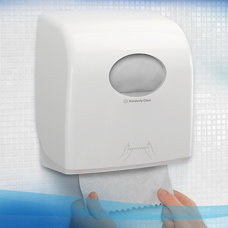 Distributeur d'essuie-mains en papier blanc sur un mur, mains tirant l'essuie-mains.