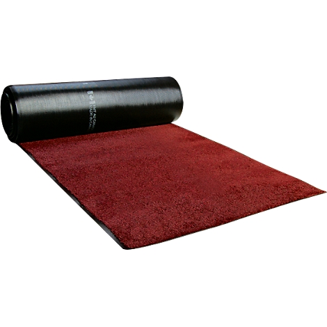 Una alfombra roja desenrollada, desenrollada de un rollo negro.