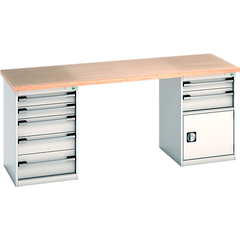 Établi avec plateau en bois, tiroirs gris et armoire.