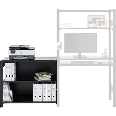 Bureau noir avec des classeurs, une imprimante et des magazines. La partie droite montre un bureau avec un PC en filigrane.