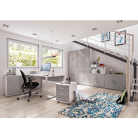 Un bureau moderne. Un bureau avec ordinateur, chaise et caisson mobile au premier plan. Des armoires et un escalier en arrière-plan.
