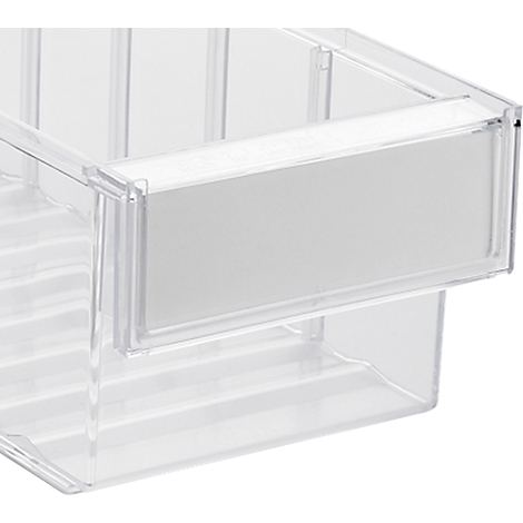 Nahaufnahme einer transparenten Kunststoffbox, mit weißem Etikett. Der Fokus liegt auf dem Etikettbereich.