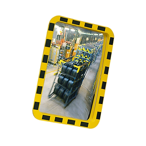 Yellow safety mirror with black warning stripe, showing warehouse. Reflection of shelves with black tires.