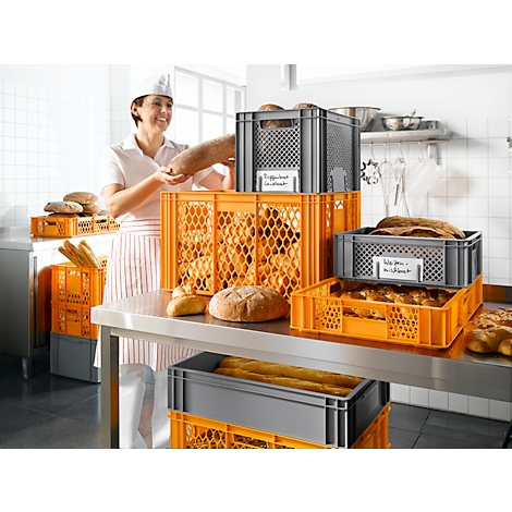 Bäckerin mit Brot. Mehrere Körbe mit Brot, Brötchen und Baguettes.