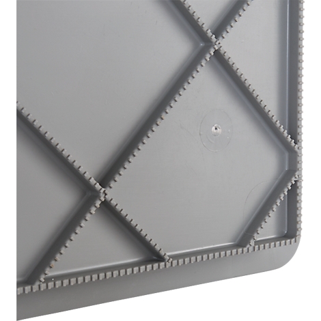 Surface en plastique gris avec des motifs en losange en relief, entourée d'un bord dentelé.