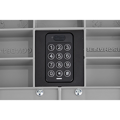 Nahaufnahme eines schwarzen Zahlenschlosses mit weißen Ziffern. Es ist in einen grauen Rahmen eingelassen und von grauem Kunststoff umgeben.