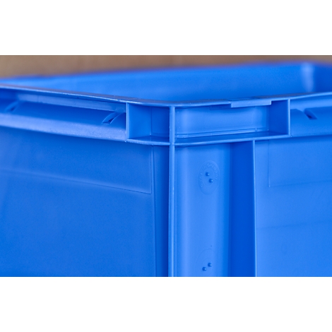 Corner of a blue plastic box, detail shot with visible connections and recesses.