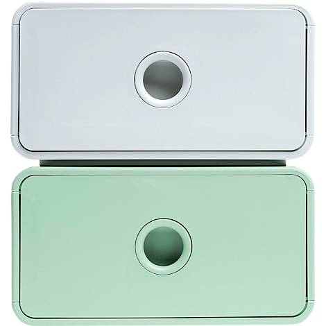 Deux boîtes de rangement empilables, blanches et vert menthe, avec des ouvertures circulaires au centre.