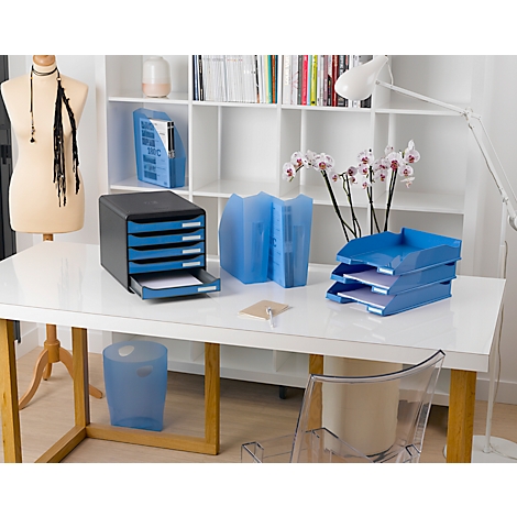 Bürotisch mit blauen Ablagen, Papierkorb, Ordnern und Dekoration. Heller Raum mit Schreibtisch und Bücherregal.