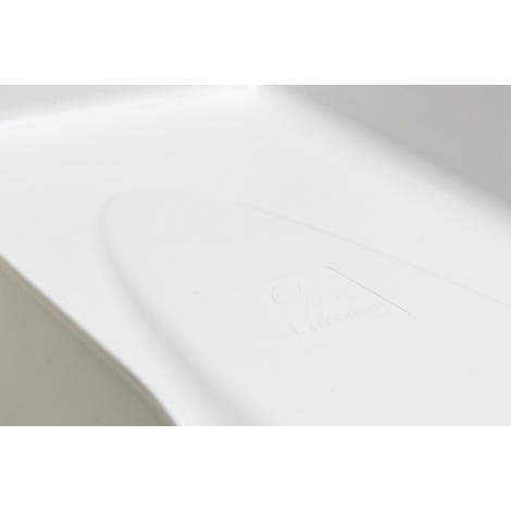 Gros plan d'un objet blanc et arrondi avec un marquage formé. L'objet a une surface lisse.