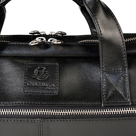 Detailaufnahme einer schwarzen Ledertasche mit Reißverschluss, Tragegriff und Logo-Emblem.