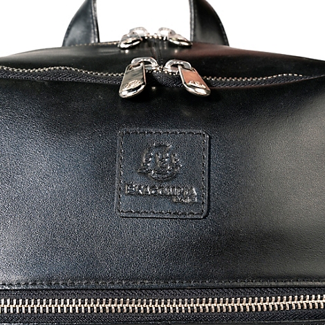 Gros plan d'un sac en cuir noir avec fermeture éclair, fermetures éclair argentées et une étiquette en cuir.