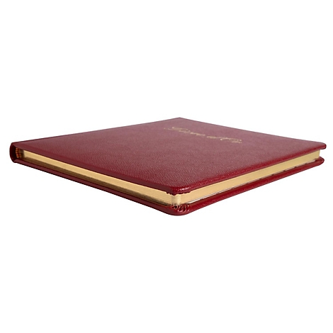 Weinrotes Notizbuch mit goldenem Buchschnitt, leicht schräg, vor weißem Hintergrund.