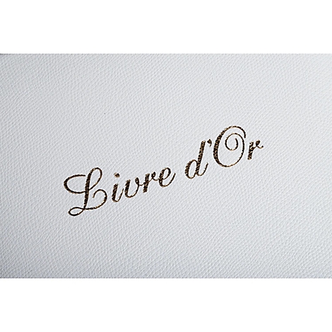 Nahaufnahme eines weißen Leders mit dem Schriftzug "Livre d'Or" in Gold.
