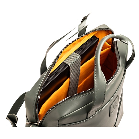 Hellgrüne Ledertasche, Reißverschluss geöffnet, Blick in das orangefarbene Innenfutter. Ein Laptop wird gehalten.